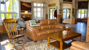 sala de estar con sofá de cuero marrón y mesa en Cedar Hill Lodge en Saint Ignace