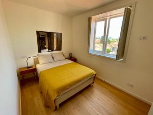 1 dormitorio con 1 cama con colcha amarilla y ventana en Uporto House Palace en Oporto