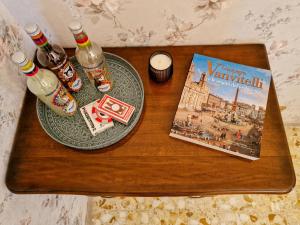 einem Holztisch mit einem Buch und einem Teller mit Getränken in der Unterkunft Grazia Guesthouse in Rom
