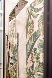 baño con papel pintado con motivos florales en la pared en Cavour central apartment, en Turín