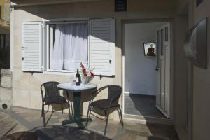 mesa y sillas en una habitación con ventana en Guest House Kušeta, en Split
