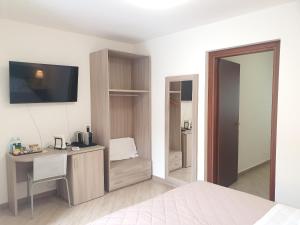 a bedroom with a bed and a desk and a tv at RipamontiBnB in Milan