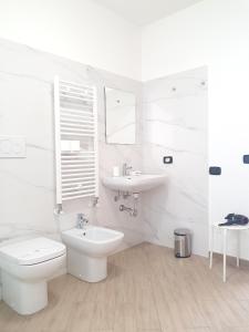 a white bathroom with a toilet and a sink at RipamontiBnB in Milan