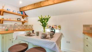 a kitchen with a table with cups on it at Pipistrelle Barn in Kniveton