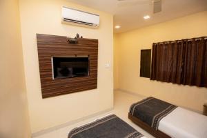 a bedroom with a fireplace and a tv on the wall at Hotel Elite 59 in Mumbai