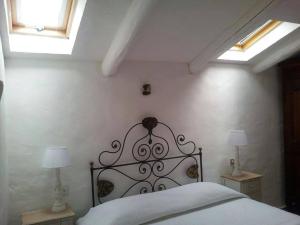 ein Schlafzimmer mit einem Bett mit zwei Lampen und zwei Fenstern in der Unterkunft Apartment Alba in Porto Cervo