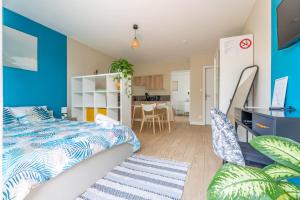 sypialnia z łóżkiem i niebieską ścianą w obiekcie Studio GDX Privilége - Bourg en Bresse - Centre ville & Gare w mieście Bourg-en-Bresse