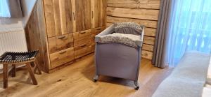ein Babybett in einem Zimmer mit Kommode in der Unterkunft Almchalet Schuster in Diex
