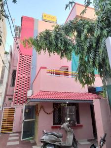 a scooter parked in front of a pink building at SPOT ON 66976 Tirupati Guest House in Gwalior