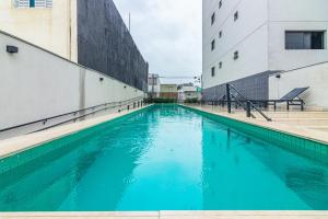una piscina de agua azul entre dos edificios en 360 Vita Bom Retiro, en São Paulo
