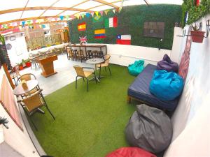 a room with a bed and chairs and a table at Dragonfly Hostels Miraflores in Lima