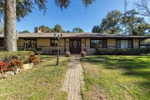 una casa con un árbol y un camino de ladrillo en Withlacoochee Riverhouse, en Yankeetown