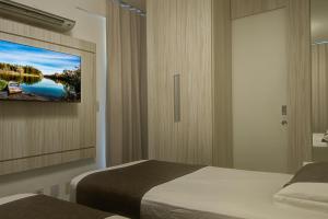 sypialnia z łóżkiem i telewizorem na ścianie w obiekcie Villa Beira Mar w mieście Fortaleza