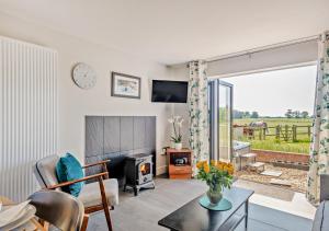 a living room with a fireplace and a tv at Swallows Return - Colkirk in Colkirk