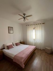 - une chambre avec un lit et un ventilateur de plafond dans l'établissement Apartment Nela, à Brna