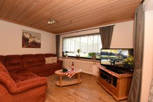 a living room with a couch and a flat screen tv at Ferienwohnung Allgäuer Bergnest in Fischen