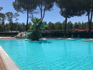 einen Pool mit blauem Wasser in einem Resort in der Unterkunft Casa vacanza dentro al villaggio Santandrea in SantʼAndrea Apostolo dello Ionio