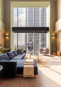a living room with a blue couch and large windows at Casa Magenta by Kukun in Mexico City