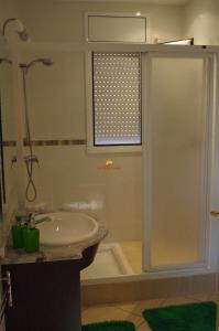 een badkamer met een douche en een wastafel bij L'Eden in Les tres Cales