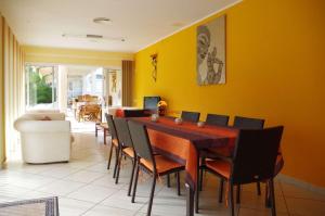 een eetkamer met gele muren en een tafel en stoelen bij L'Eden in Les tres Cales