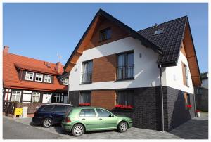 a green car parked in front of a house at Helios in Ustka