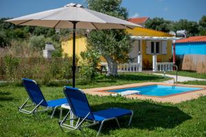 twee stoelen en een parasol naast een zwembad bij G&G Villas in Spartia