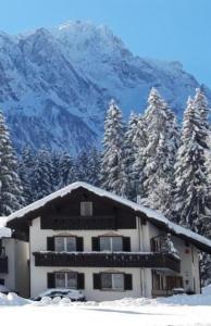 een met sneeuw bedekt huis voor een berg bij Gästehaus Lehnerer Grainau in Grainau