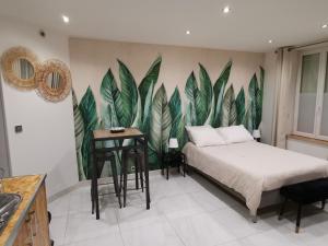 a bedroom with a bed and a plant mural on the wall at Studio entre Paris et Versailles in Le Port-Marly