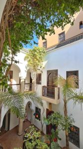 - un bâtiment avec des balcons et des arbres en face dans l'établissement Riad Dar Zaman, à Marrakech