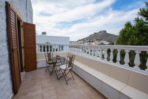 a balcony with a table and chairs and a view at BunnyFoot: Country house of 135 sqm in Leros. in Panteli