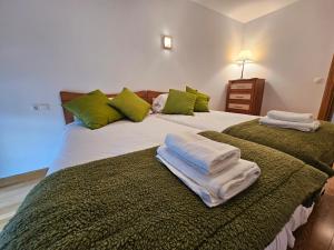 a bedroom with a large bed with towels on it at 13B01 Apartamento con terraza y garaje in Ribadesella