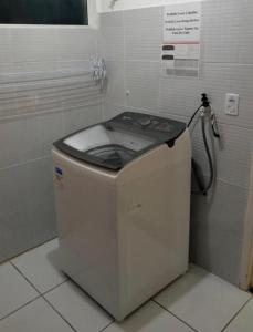 pralka w łazience wyłożonej białymi kafelkami w obiekcie Lindo Flat em Ponta Negra - Natal w mieście Natal