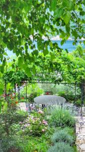 einen Tisch und Stühle in einem Garten unter einem Baum in der Unterkunft Casa Vita Nova in Perast