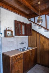 a kitchen with a sink and wooden cabinets at BunnyFoot: Country house of 135 sqm in Leros. in Panteli