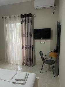 サランダにあるVila Mateoのベッド、椅子、テレビが備わる客室です。