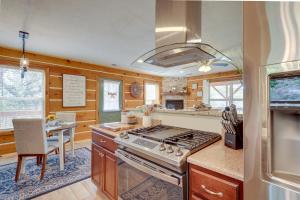a kitchen with wooden walls and a stove top oven at Jemez Springs Cabin with Deck and Mountain Views! in Jemez Springs