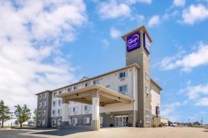 a hotel with a sign on top of it at Sleep Inn & Suites Hays I-70 in Hays