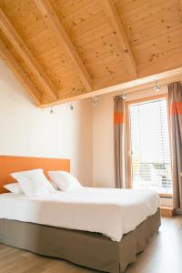 ein Schlafzimmer mit einem großen Bett und einem großen Fenster in der Unterkunft Ame de la Terre in Ruffey-lès-Échirey