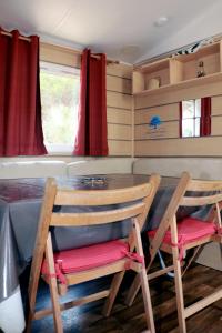 a dining room with two chairs and a table at Mobilhome «Perle marine»*6 personnes *3 Chambres*TV in Sigean