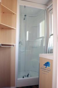 a shower with a glass door in a bathroom at Mobilhome «Perle marine»*6 personnes *3 Chambres*TV in Sigean