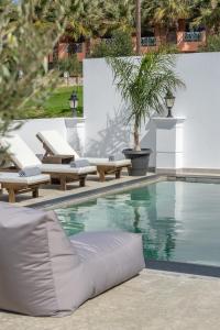 a swimming pool with chaise lounge chairs and a swimming pool at Saint Dionysius Villa in Kalamaki