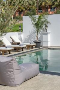 a swimming pool with chaise lounge chairs and a swimming pool at Saint Dionysius Villa in Kalamaki