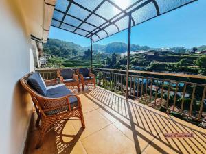 a balcony with chairs and a view of the mountains at Vue D'en Haut, Ooty in Ooty