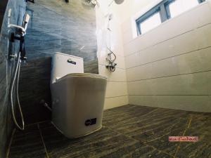 a shower stall with a toilet in a bathroom at Vue D'en Haut, Ooty in Ooty