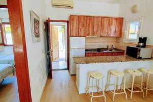 a kitchen with a counter and stools in a room at Precioso Bungalow 4 by CASAS COCODRILO in Playa del Ingles