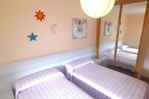 een kamer met 2 bedden en een spiegel bij Vistas al mar con jardín privado, piscina y padel in Foz