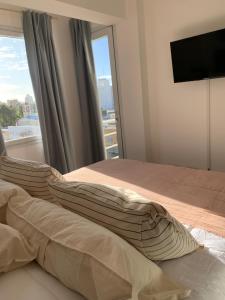 a bedroom with a bed and a large window at Depto Caleta Madryn in Puerto Madryn