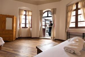 a person standing in a bedroom looking out the window at Vibes Aurik in Quito