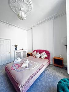 ein Schlafzimmer mit einem rosa Bett mit einem ausgestopften Tier darauf in der Unterkunft New Marylebone Gem/One Bedroom in London