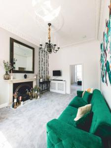 ein Wohnzimmer mit einer grünen Couch und einem Kamin in der Unterkunft New Marylebone Gem/One Bedroom in London